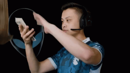 A Man Wearing A Headset Holds Up A 20 Dollar Bill GIF