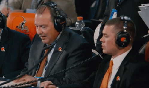 A Man Wearing A Headset With A Cleveland Browns Logo On His Shirt GIF