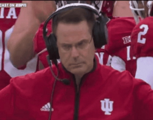 A Man Wearing A Headset With The Letter I On His Jacket GIF