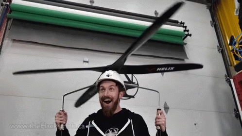 A Man Wearing A Helix Helmet Holds A Propeller In His Hands GIF