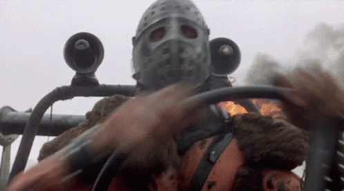 A Man Wearing A Helmet And A Mask Is Driving A Car GIF