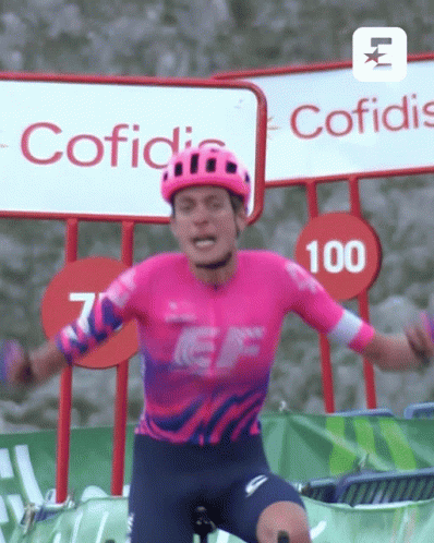 A Man Wearing A Helmet And A Pink Shirt With The Number 100 On It GIF