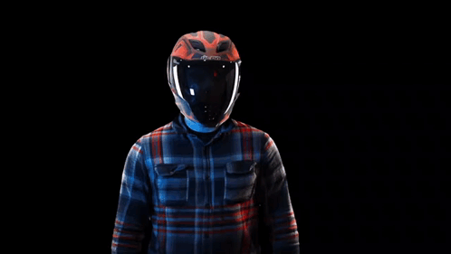 A Man Wearing A Helmet And A Plaid Shirt Is Standing In Front Of A Black Background . GIF