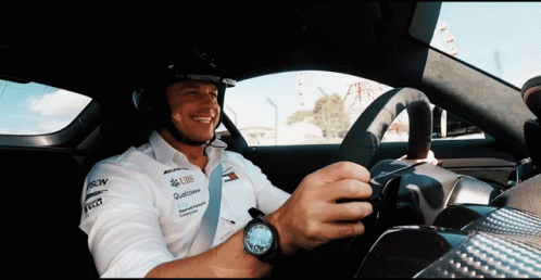 A Man Wearing A Helmet And A Shirt That Says Ubs Is Driving A Car GIF