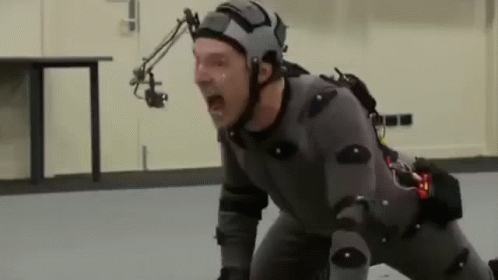 A Man Wearing A Helmet And A Suit Is Screaming While Kneeling On The Floor . GIF