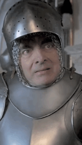 A Man Wearing A Helmet And Armor Looks At The Camera GIF