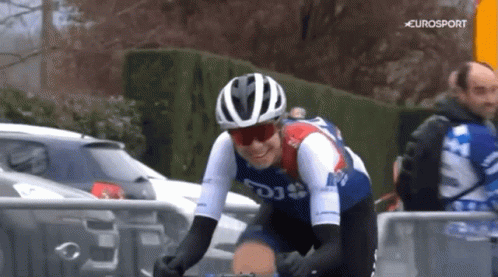 A Man Wearing A Helmet And Sunglasses Is Riding A Bike With Eurosport In The Background GIF