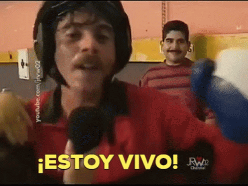 A Man Wearing A Helmet Is Holding A Microphone And Saying Estoy Vivo GIF