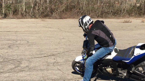 A Man Wearing A Helmet Is Riding A Motorcycle GIF