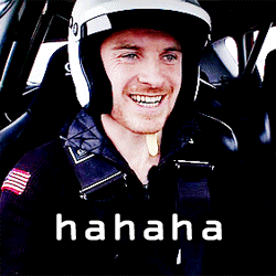 A Man Wearing A Helmet Is Smiling In A Car With The Word Hahaha Written Below Him GIF