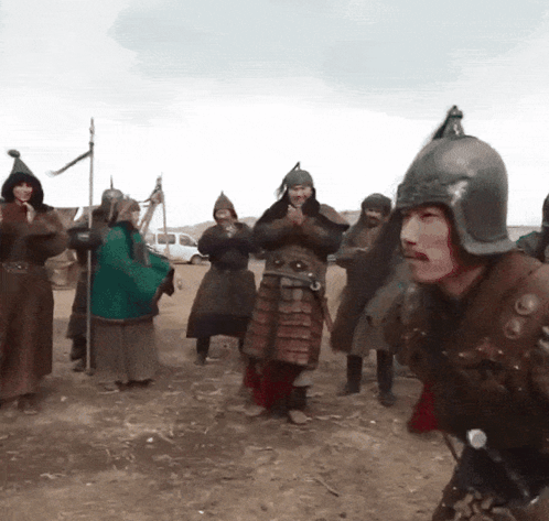 A Man Wearing A Helmet Is Surrounded By Other Men In Armor GIF