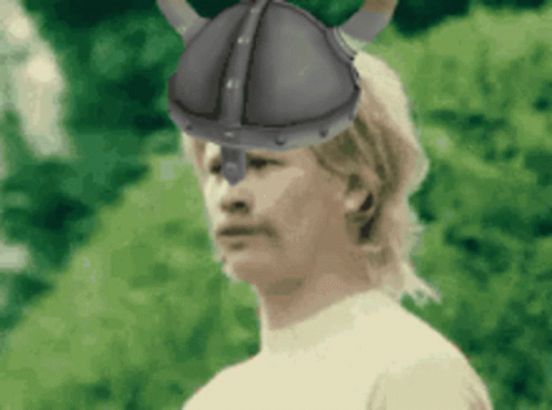 A Man Wearing A Helmet With Horns On It GIF