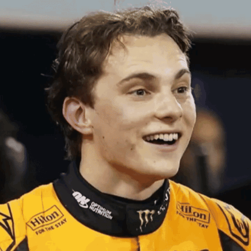 A Man Wearing A Hilton For The Stay Shirt Smiles For The Camera GIF