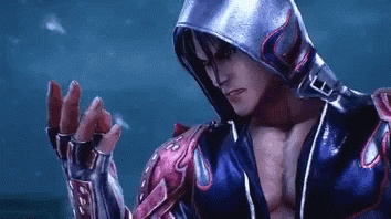 A Man Wearing A Hooded Jacket And Gloves Is Standing In Front Of A Blue Background . GIF