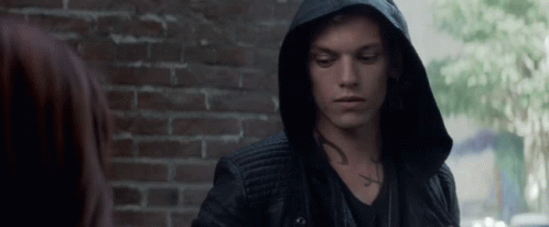 A Man Wearing A Hooded Jacket Has A Tattoo On His Chest GIF