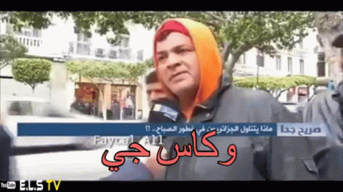 A Man Wearing A Hooded Jacket Talks Into A Microphone While Being Interviewed By A Youtube Channel Called Elstv GIF