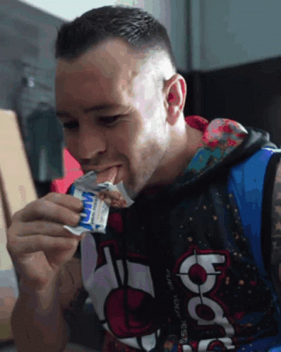 A Man Wearing A Hoodie That Says Nba Is Eating A Snack GIF