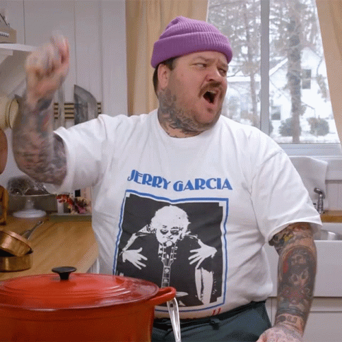 A Man Wearing A Jerry Garcia T-Shirt Is Standing In A Kitchen GIF