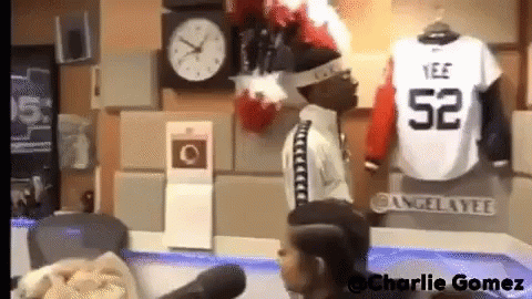 A Man Wearing A Jersey With The Number 52 Stands In Front Of A Microphone GIF