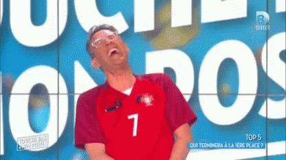A Man Wearing A Jersey With The Number 7 On It Laughs GIF