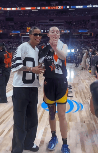 A Man Wearing A Jersey With The Number 8 On It Stands Next To Another Man GIF