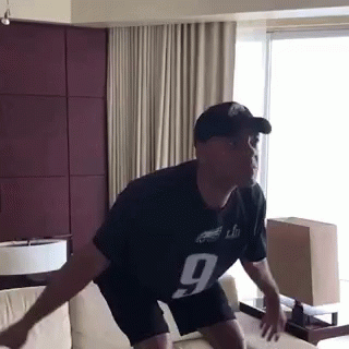 A Man Wearing A Jersey With The Number 9 On It Is Jumping On A Couch GIF