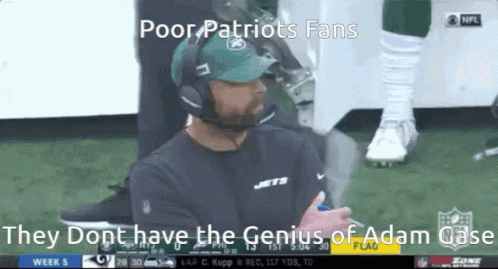 A Man Wearing A Jets Hat And Headphones Is Sitting On The Sidelines During A Football Game GIF