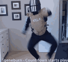 A Man Wearing A Killa Vest Is Dancing In A Room GIF