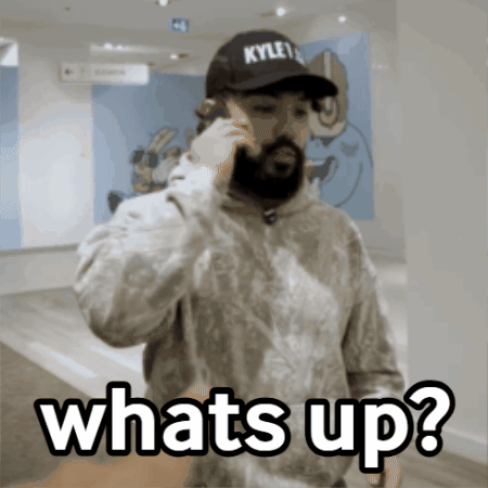 A Man Wearing A Kyle 'S Hat Is Talking On A Cell Phone And Says Whats Up GIF