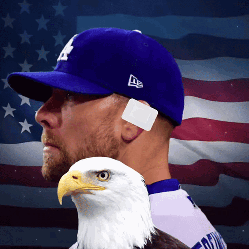 A Man Wearing A La Hat Holds A Bald Eagle In Front Of An American Flag GIF
