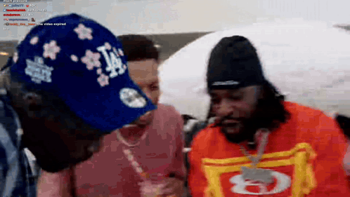A Man Wearing A La Hat Is Standing Next To A Woman GIF