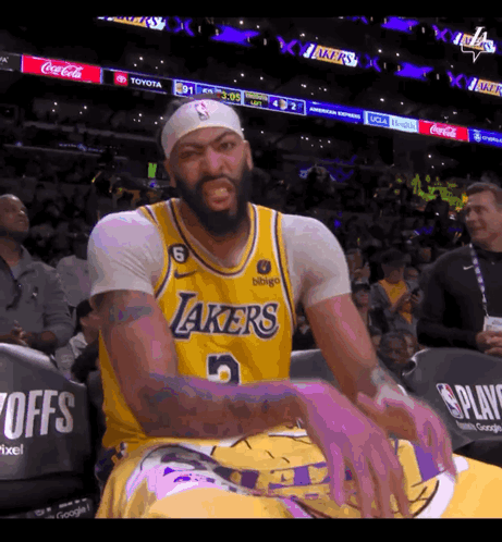 A Man Wearing A Lakers Jersey Is Sitting In The Stands GIF