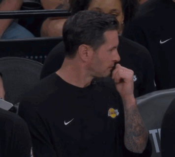 A Man Wearing A Lakers Shirt Is Sitting In A Crowd Of People GIF