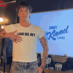 a man wearing a lana del rey t-shirt stands in front of jimmy kimmel live