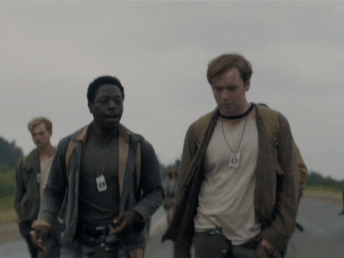 A Man Wearing A Lanyard With The Number 49 On It Walks Down A Road GIF