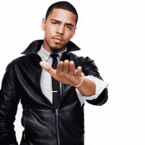 a man wearing a leather jacket and tie is making a stop gesture