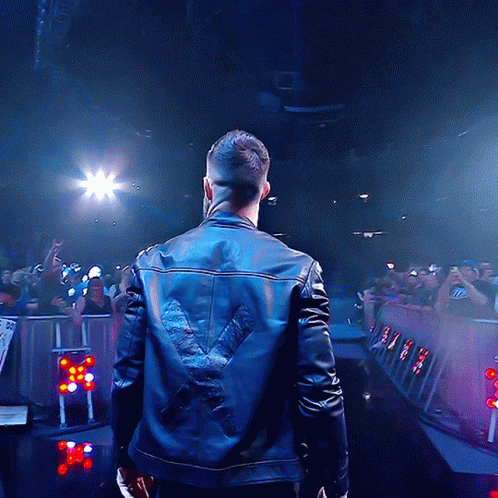 A Man Wearing A Leather Jacket With A X On The Back GIF