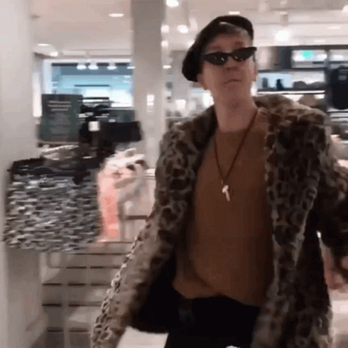 A Man Wearing A Leopard Print Coat And Sunglasses GIF