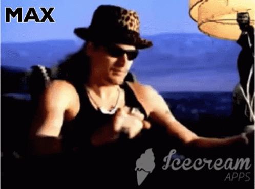 A Man Wearing A Leopard Print Hat And Sunglasses Is Sitting In Front Of An Ice Cream Advertisement GIF