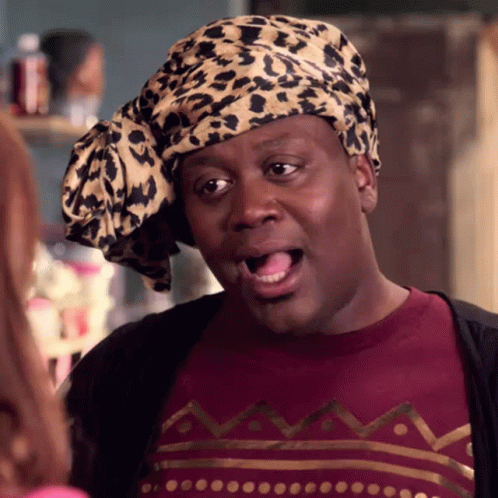 A Man Wearing A Leopard Print Head Scarf And A Maroon Shirt GIF