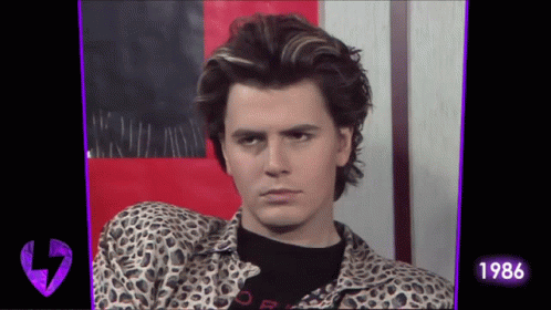 a man wearing a leopard print shirt and a black shirt with the year 1986 on it