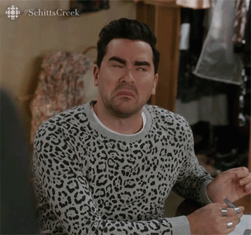 A Man Wearing A Leopard Print Sweater With #Schitts Creek Written On The Bottom GIF