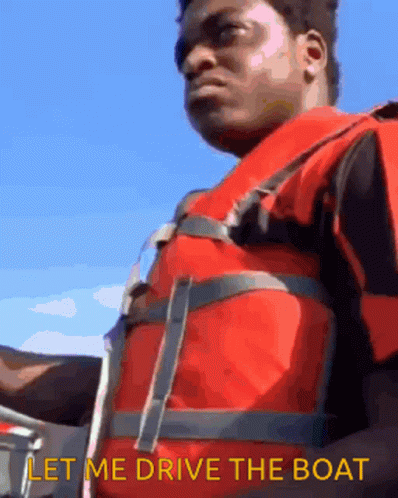 A Man Wearing A Life Vest Says Let Me Drive The Boat GIF