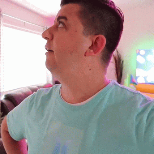 A Man Wearing A Light Blue Shirt With The Letter S On It GIF