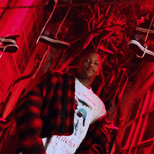 A Man Wearing A Macho Shirt Stands In Front Of A Red Light GIF