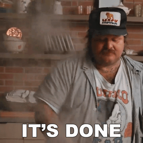 A Man Wearing A Mack Hat Says It 'S Done In A Kitchen GIF