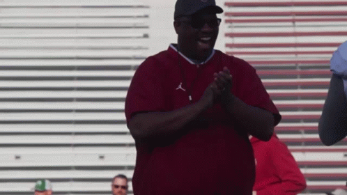 a man wearing a maroon shirt with the letters j on it