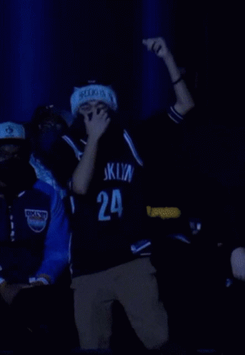 A Man Wearing A Mask And A Brooklyn Jersey Is Dancing GIF