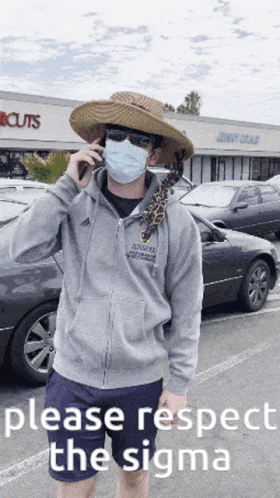 A Man Wearing A Mask And A Hat Is Talking On A Cell Phone In Front Of A Store That Says Cuts GIF