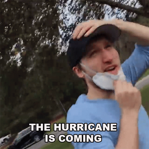 A Man Wearing A Mask And A Hat Says The Hurricane Is Coming GIF